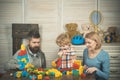 Father, mother and son in playroom on light wooden background. Royalty Free Stock Photo