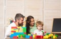 Father, mother and son in playroom on light wooden background. Royalty Free Stock Photo