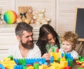 Father, mother and son in playroom on light wooden background. Royalty Free Stock Photo