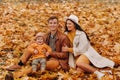 Father and mother with son sitting in the autumn Park. Portrait of a Golden autumn Family in a nature Park. Royalty Free Stock Photo