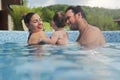 Father and mother teaching small child swimming in the pool Royalty Free Stock Photo
