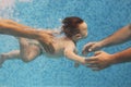 Father and mother teaching small child swimming underwater in the pool Royalty Free Stock Photo