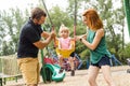 Father, mother with their daughter have fun on a swing Royalty Free Stock Photo