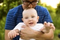 Father in nature holding baby son in the arms, kissing him. Royalty Free Stock Photo