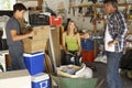 Father Organising Two Teenagers Clearing Garage For Yard Sale Royalty Free Stock Photo