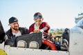 Father pilot teaching son to do repair works, explains arrangement of gear