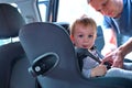 Father placing his son in the car seat Royalty Free Stock Photo