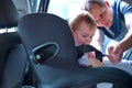 Father placing his son in the car seat Royalty Free Stock Photo