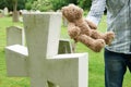 Father Placing Teddy Bear On Child's Grave In Cemetery Royalty Free Stock Photo