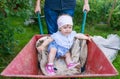 Father playing with baby daughter using trolley on meadow Royalty Free Stock Photo