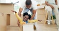 Father, playing and child in a box while moving house with a black family together in a living room. Man and a girl kid Royalty Free Stock Photo