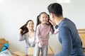 Father playing cute little daughter doing riding in cardboard boxes,  young Asian family kids having fun in new house living room Royalty Free Stock Photo