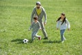 father playing football with children on grass