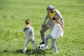 father playing football with children on grass