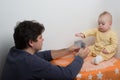 Young father is playing with his baby. Young dad with a baby plays cards Royalty Free Stock Photo