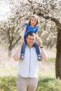 Father playing with his daughter in the park. Daughter sitting on father shoulders. Portrait of happy family. father`s, baby`s d Royalty Free Stock Photo