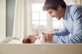 Father Playing With Newborn Baby Lying On Changing Table Royalty Free Stock Photo