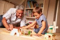 Father playing with son and toys on the floor in a playroom Royalty Free Stock Photo