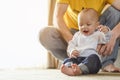 Father playing with toddler baby son having fun at home in holiday.