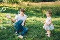 Father plays with his daughter with soapbubble