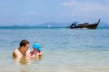 Father plays with his daughter in the water at sea. Speed  longtail boat sailing on background Royalty Free Stock Photo