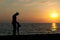 Father plays with son against a sunset