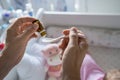 Father preparing spoon with probiotic drops medicine for his small caucasian baby girl while standing by the cradle crib at home