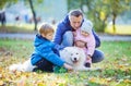 Father with preschool son and baby daugther playing with his samoyed dog Royalty Free Stock Photo