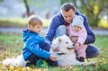Father with preschool son and baby daugther playing with samoyed dog in park Royalty Free Stock Photo