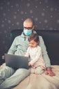 Father in protective mask working from home with his daughter