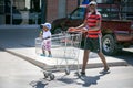 Father pushing baby boy in shopping trolley.