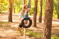 Father pushing child daughter on tire swing in summer forest. family weekend Royalty Free Stock Photo