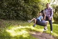 Father Pushing Children On Tire Swing In Garden Royalty Free Stock Photo