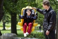 Father pushing disabled boy in special needs swing Royalty Free Stock Photo