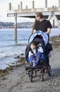 Father pushing disabled son on beach