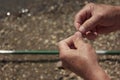 A father puts bait on a fishhook. Hands of an elderly man close-up Royalty Free Stock Photo