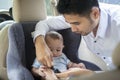 Father Putting Baby into Car Seat Royalty Free Stock Photo