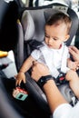 Smiling father putting baby in child seat, fastening seatbelt - Family transportation, lifestyle concept Royalty Free Stock Photo