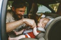 Father putting baby in safety car seat dad and child Royalty Free Stock Photo