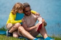 Father reading book with son in park, preparing school homework together, parenting. Summer lifestyle. Parenting and Royalty Free Stock Photo