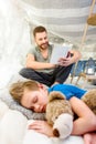 Father reading book to cute little boy sleeping with teddy bear Royalty Free Stock Photo