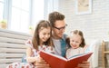 Father reading a book to his daughters Royalty Free Stock Photo