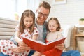 Father reading a book to his daughters Royalty Free Stock Photo