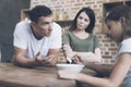 A man explains something to a sad girl, while a woman stands nearby and looks at him displeased