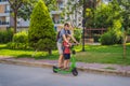 The father riding the electric scooter with his son in the city