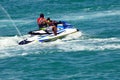 Father riding a jet ski with his toddler son on board