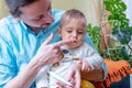 Father rubbing pain relieving gel into his little baby boy`s growing teeth. Royalty Free Stock Photo