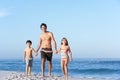 Father Running With Children Along Sandy Beach