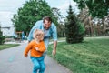 Father running with toddler son, chasing him for fun in park Royalty Free Stock Photo