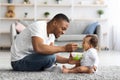 Father's Care. Loving Black Dad Feeding His Cute Baby Son At Home Royalty Free Stock Photo